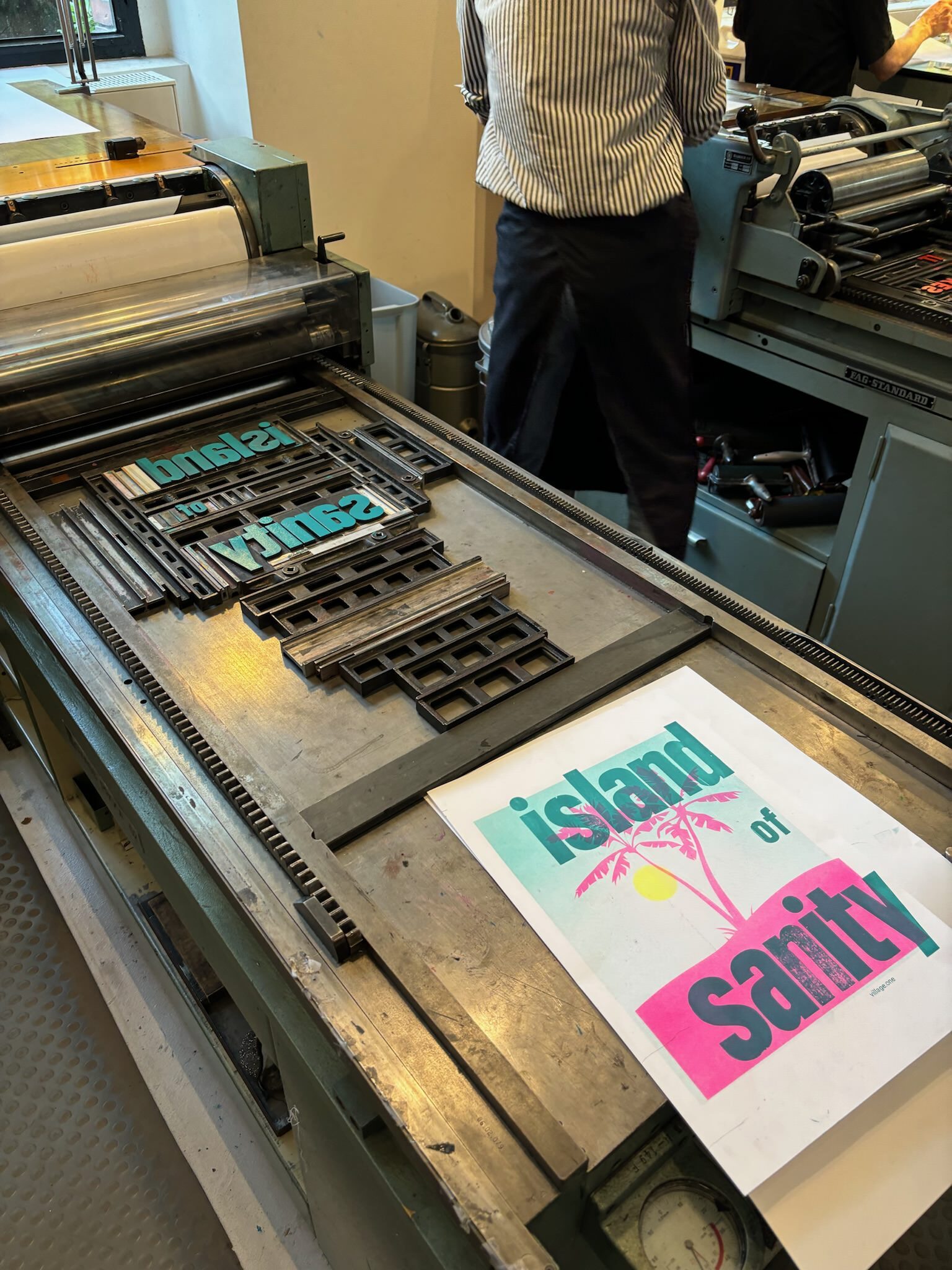 Photo of a finished poster, saying “Island of Sanity” over a palm tree background