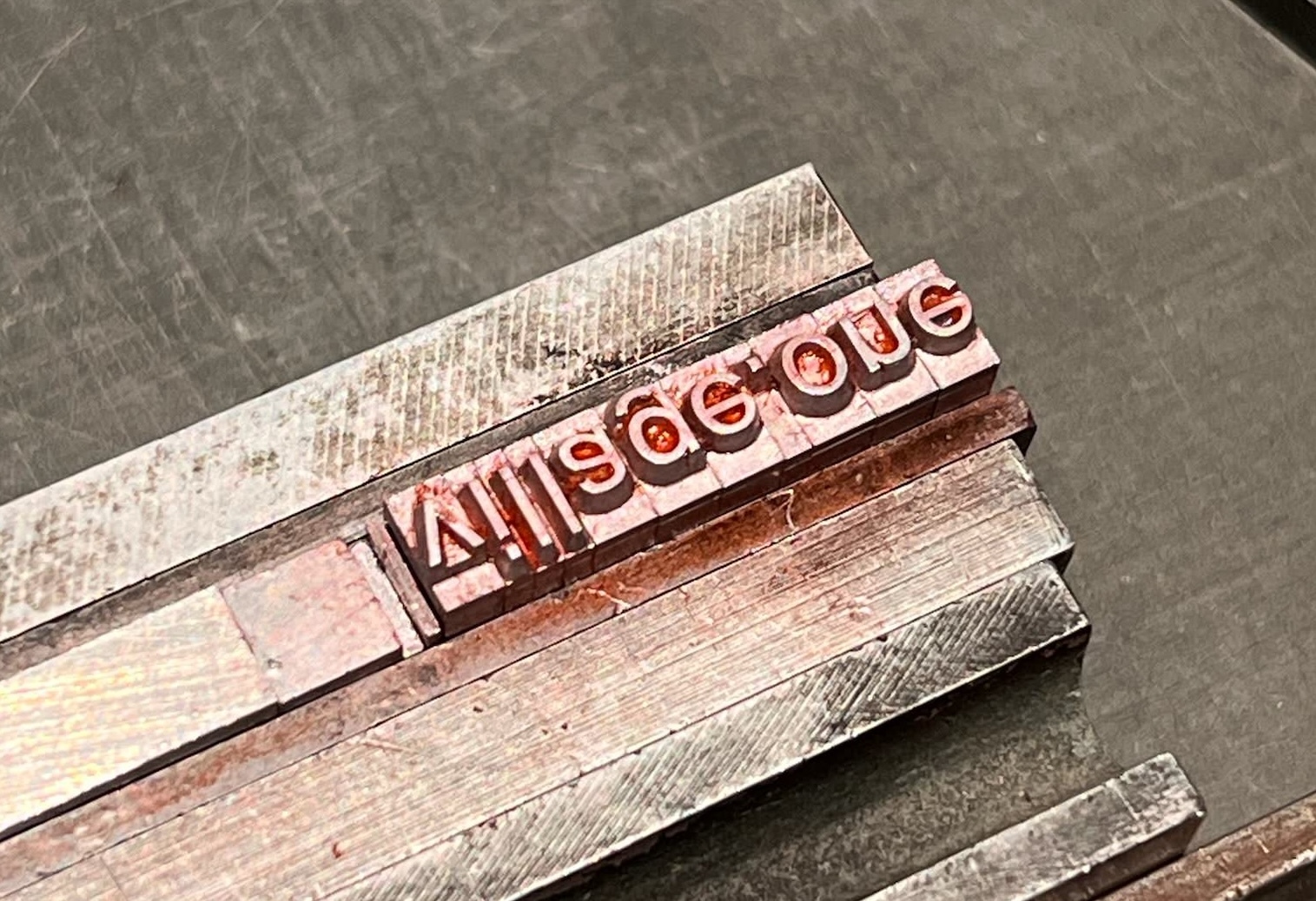 Photo of metal type spelling out “village.one”